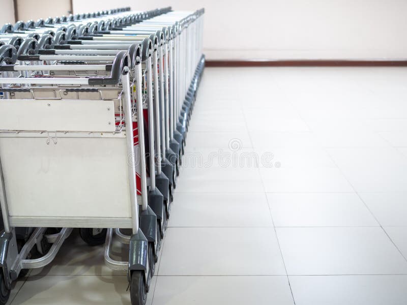 Reihe von Flughafengepäckwagen im Flughafenabfertigungsgebäude stockfotografie Reihe von Flughafengepäckwagen im Flughafenabfertigungsgebäude stockfotografie