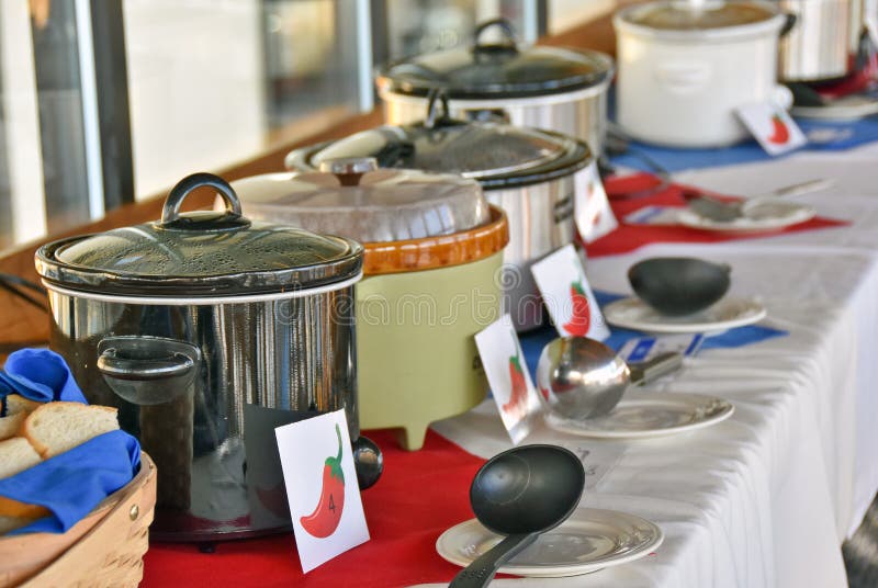 Row of crock pots with signs and ladles for chili cook off contest. Row of crock pots with signs and ladles for chili cook off contest.