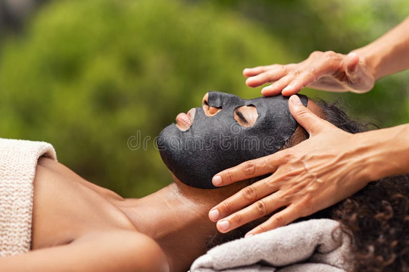 Reinigen der schwarzen Schönheitsmaske auf dem Gesicht der Frau stockfotografie Reinigen der schwarzen Schönheitsmaske auf dem Gesicht der Frau stockfotografie