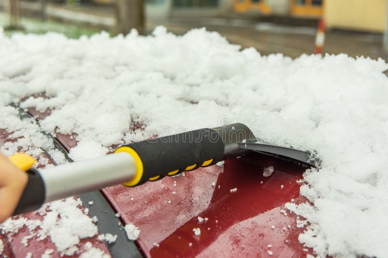 Reinigung der Schneebeseitigung nach schwerem Schneeausschnitt mit Bürstenabbürsten aus Autodach im Winter Sturmnachfolge lizenzfreies stockbild Reinigung der Schneebeseitigung nach schwerem Schneeausschnitt mit Bürstenabbürsten aus Autodach im Winter Sturmnachfolge lizenzfreies stockbild