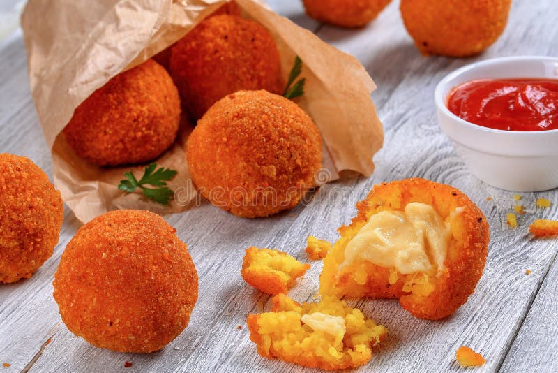 Reisbälle angefüllt mit Käse im Papierkornett lizenzfreies stockbild Reisbälle angefüllt mit Käse im Papierkornett lizenzfreies stockbild