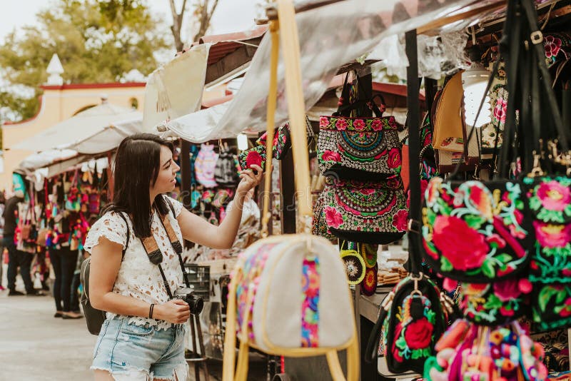 Reisende Mädchen kaufen Souvenirs auf dem traditionellen mexikanischen Markt in Mexiko Straßen, hispanische Touristen im Freien L stockfoto Reisende Mädchen kaufen Souvenirs auf dem traditionellen mexikanischen Markt in Mexiko Straßen, hispanische Touristen im Freien L stockfoto