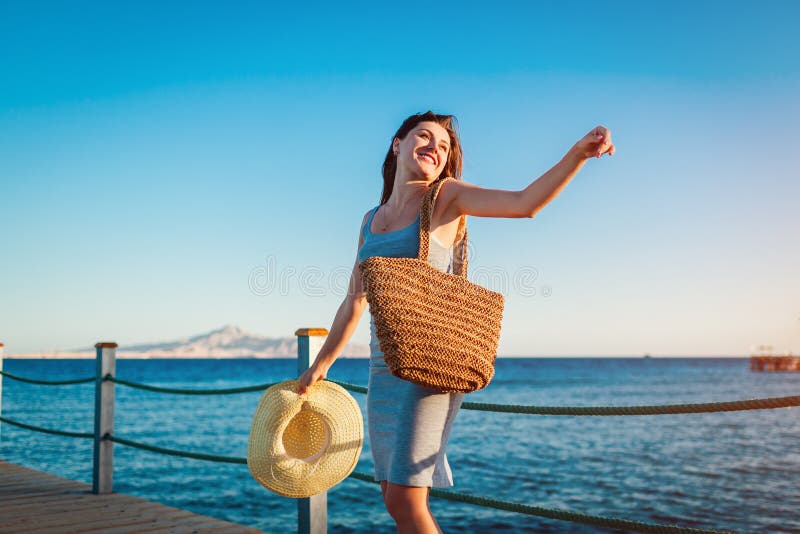 Reisender der jungen Frau ?ffnet Arme und das F?hlen gl?cklich und frei auf Pier durch Rotes Meer lizenzfreie stockfotografie Reisender der jungen Frau ?ffnet Arme und das F?hlen gl?cklich und frei auf Pier durch Rotes Meer lizenzfreie stockfotografie