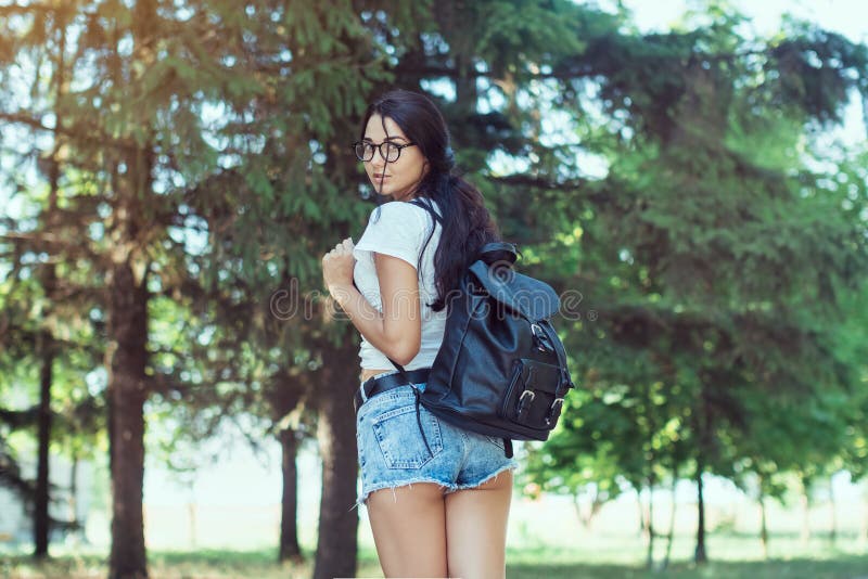 Reisender der jungen Frau mit dem Rucksack, der allein im Waldhippie-Mädchen im sonnigen Holz steht lizenzfreies stockfoto Reisender der jungen Frau mit dem Rucksack, der allein im Waldhippie-Mädchen im sonnigen Holz steht lizenzfreies stockfoto