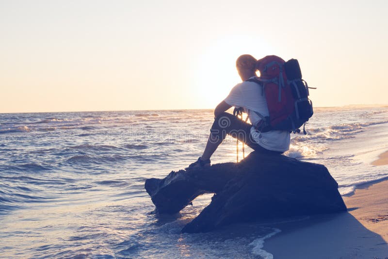 Reisender mit Rucksack sitzt nahe bei Meer stockfotos Reisender mit Rucksack sitzt nahe bei Meer stockfotos