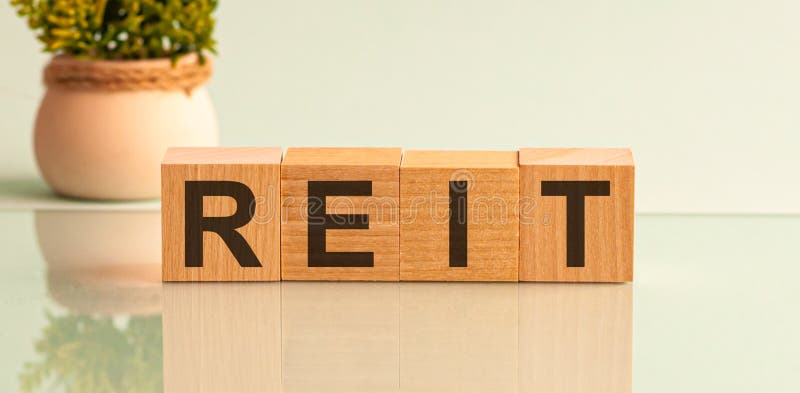 REIT, real estate investment fund concept, cube wooden block with alphabet building the word REIT stock images