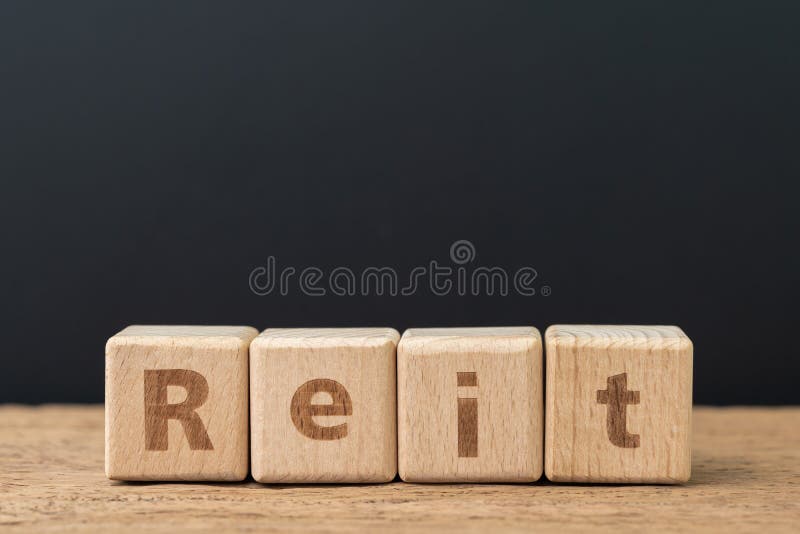 Reit, Real estate investment trust concept, cube wooden block with alphabet combine the word Reit on dark black background stock photos