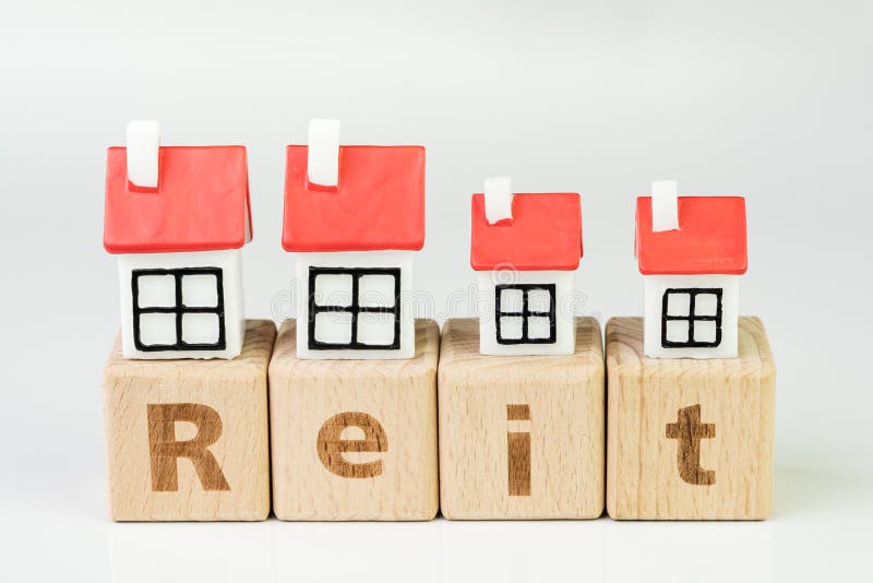 Reit, Real estate investment trust concept, miniature houses on cube wooden block with alphabet combine the word Reit on white stock image