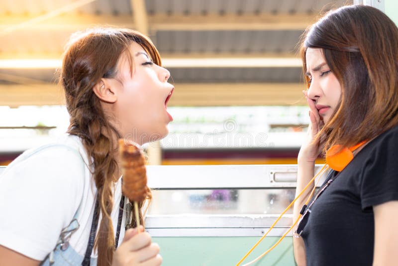 Reizendes Mädchen benutzt die nahe Hand ihre Nase weil ihre Freund pers