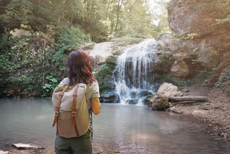 Reiziger backpacker meisje geniet van het zicht op waterval royalty-vrije stock afbeeldingen Reiziger backpacker meisje geniet van het zicht op waterval royalty-vrije stock afbeeldingen