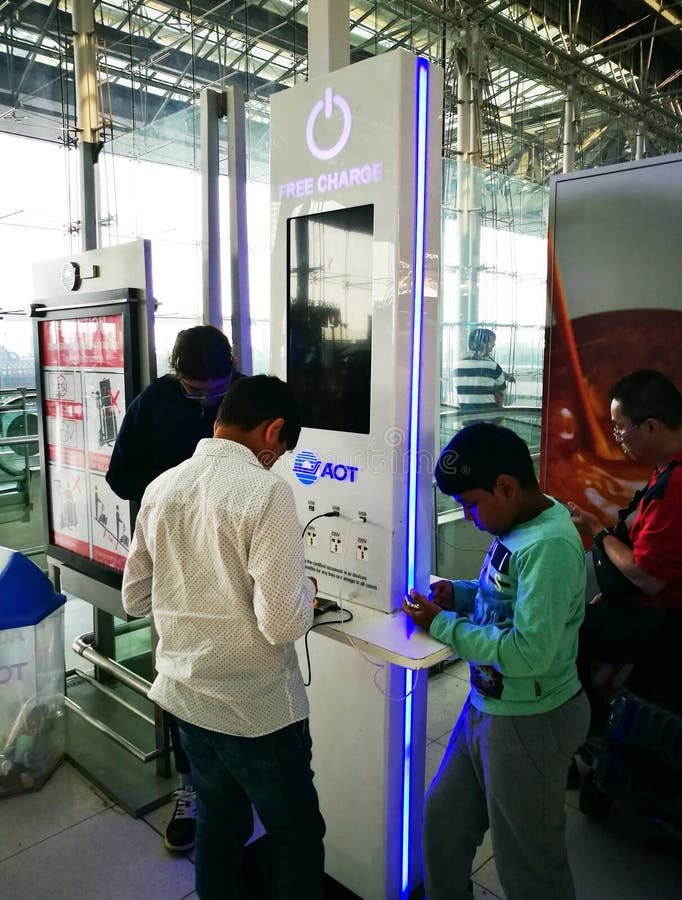 BANGKOK, THAILAND - JANUARY 6, 2018 : Traveler charging mobile phone battery at the free service charging station area at Suvarnabhumi International Airport in Bangkok, Thailand. BANGKOK, THAILAND - JANUARY 6, 2018 : Traveler charging mobile phone battery at the free service charging station area at Suvarnabhumi International Airport in Bangkok, Thailand.