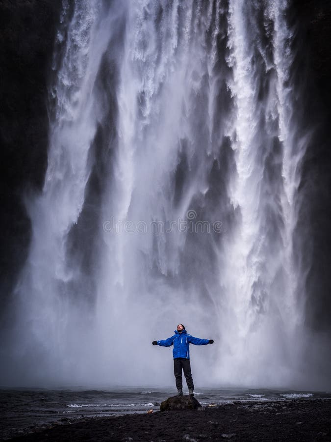 Reiziger met uitgestrekte wapens dichtbij waterval in IJsland royalty-vrije stock fotografie Reiziger met uitgestrekte wapens dichtbij waterval in IJsland royalty-vrije stock fotografie