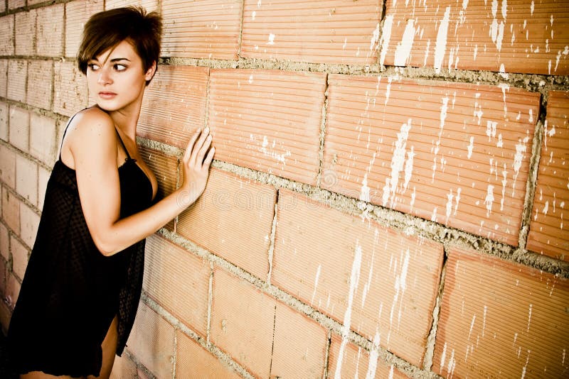 dressed young woman on dirty brickwall. dressed young woman on dirty brickwall.