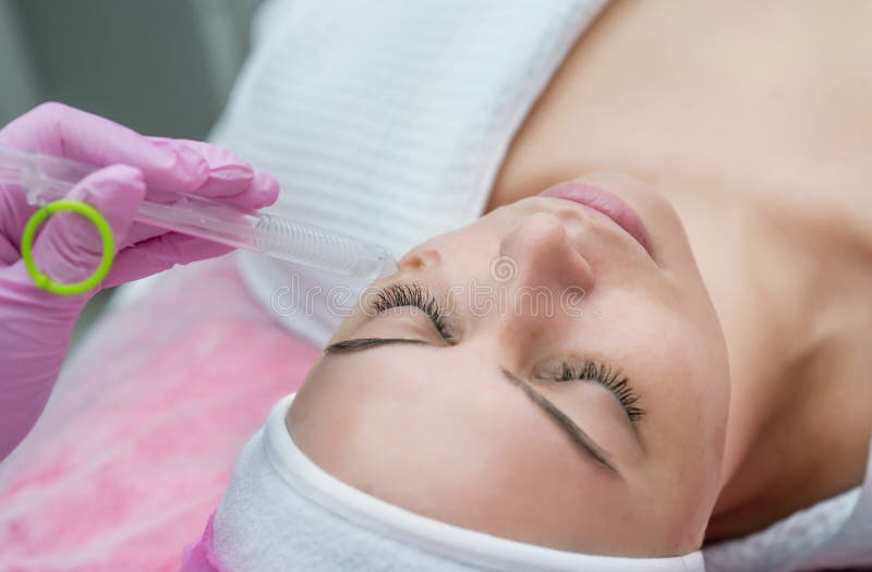 Rejuvenating facial gas liquid treatment. Woman getting face peeling procedure in a beauty SPA salon