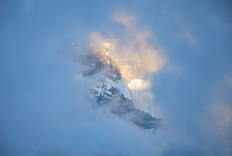 Glimpse of Machapuchare mountain through a blue cloud. Glimpse of Machapuchare mountain through a blue cloud