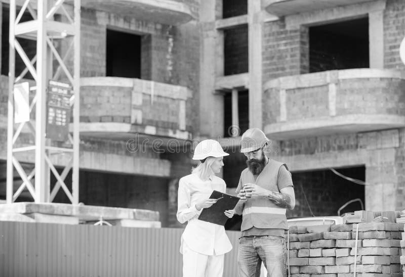 Relations entre les clients de construction et l'industrie du bâtiment de participants Ingénieur et constructeur de femme communi image stock Relations entre les clients de construction et l'industrie du bâtiment de participants Ingénieur et constructeur de femme communi image stock