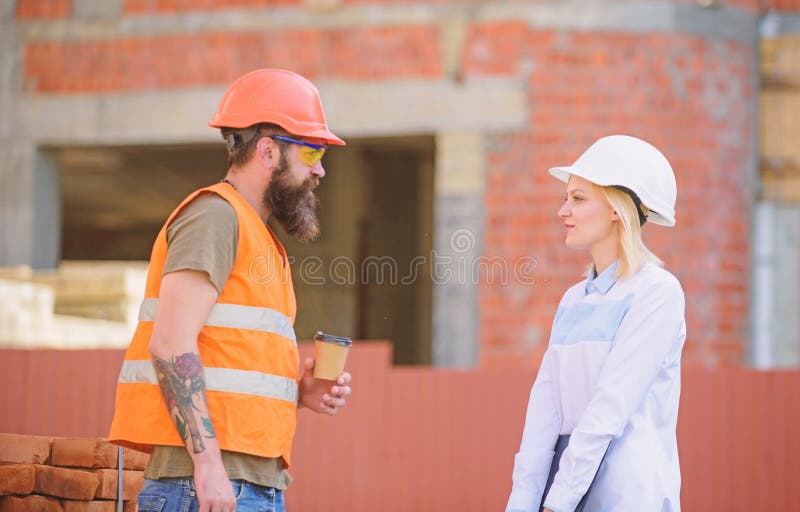 Relations entre les clients de construction et les participants de l'industrie du b?timent Ing?nieur de femme et constructeur bru photographie stock Relations entre les clients de construction et les participants de l'industrie du b?timent Ing?nieur de femme et constructeur bru photographie stock