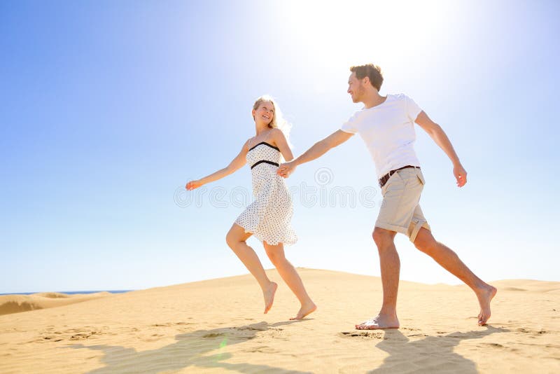 Relationship - happy couple playful romantic having fun under sun and blue sky in desert. Two young lovers running cheerful together on romance in summer. Cheerful Caucasian men and woman. Relationship - happy couple playful romantic having fun under sun and blue sky in desert. Two young lovers running cheerful together on romance in summer. Cheerful Caucasian men and woman.