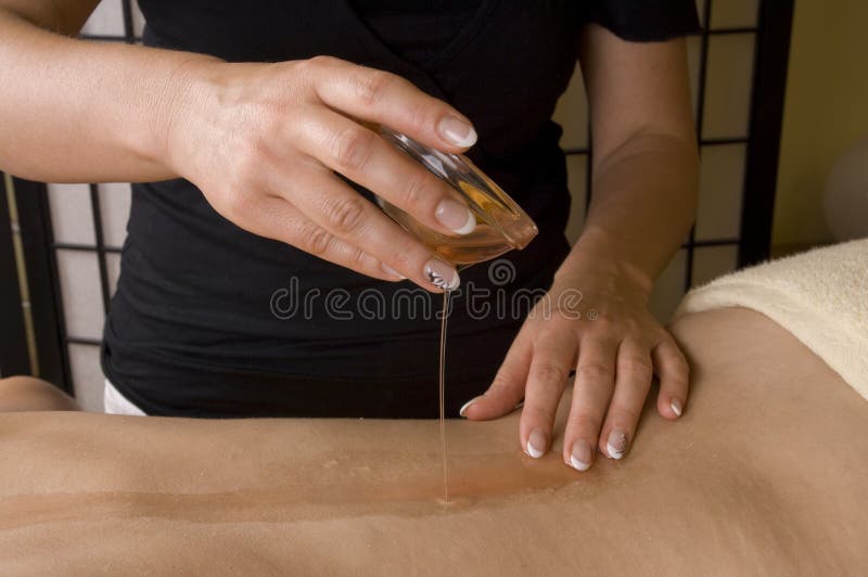 Preparazione per massaggio relax all'interno di una spa in camera, mani, mettere l'olio caldo sul retro come un primo piano immagine.