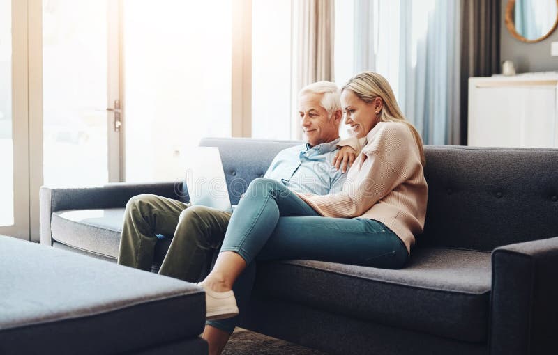 Relax, sofa and senior couple with laptop at home for online travel booking, research and information. Man, woman and royalty free stock photos
