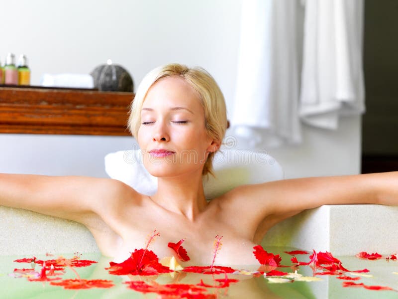 Relax, spa and flowers with woman in bath for skincare, aromatherapy or tropical vacation in Bali villa. Summer, beauty