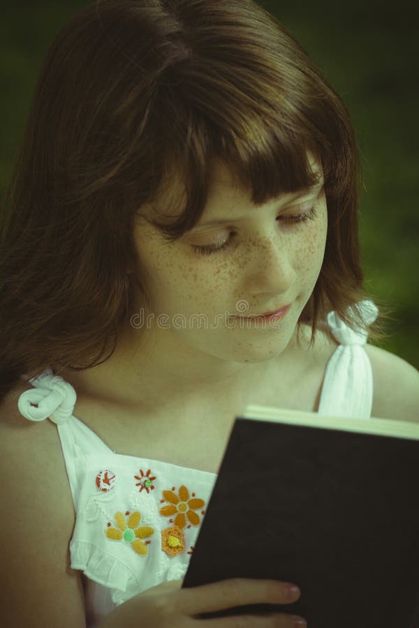 Relaxation.Young beautiful girl reading a book outdoor