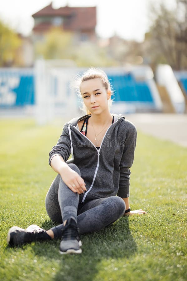 Relaxe na relva. Jovem mulher cansada após o desporto. Relaxe foto de stock royalty free