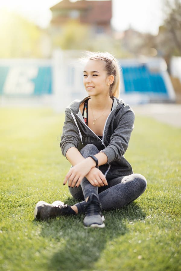 Relaxe na grama Mulher cansado nova após o esporte relaxe imagens de stock