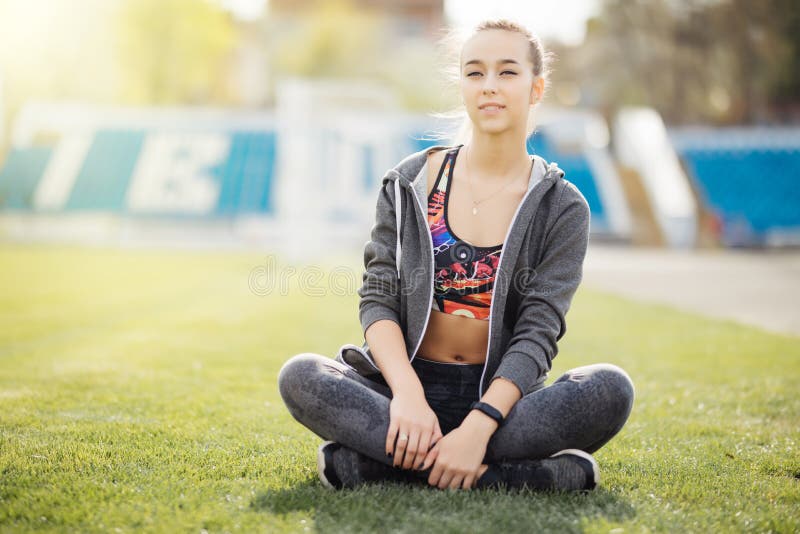 Relaxe na grama Mulher cansado nova após o esporte relaxe fotografia de stock royalty free