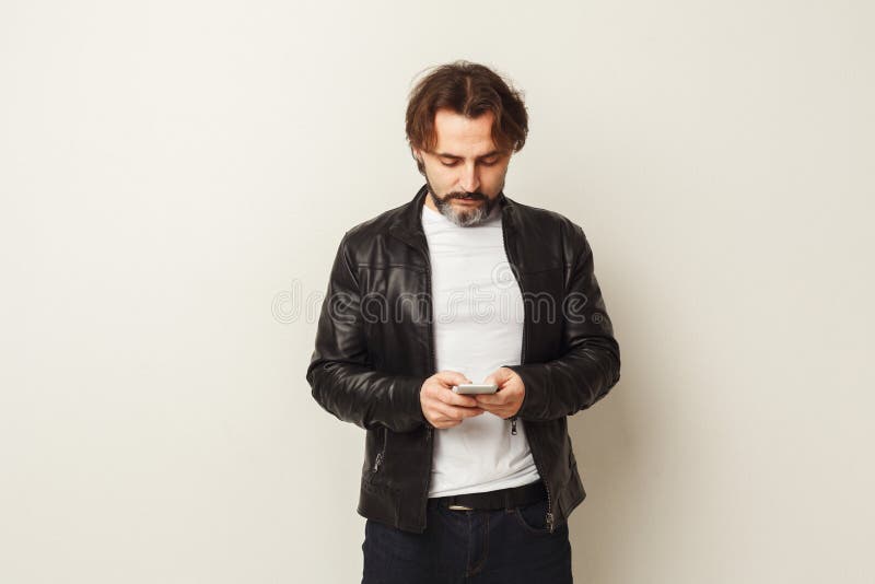 Relaxed bearded man typing message on smartphone stock image Relaxed bearded man typing message on smartphone stock image