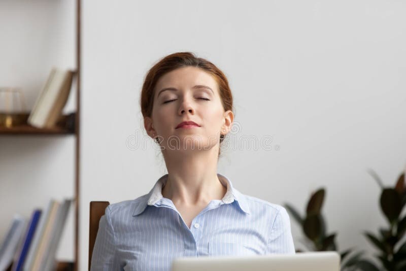 Relaxed businesswoman take deep breath of fresh air at workplace