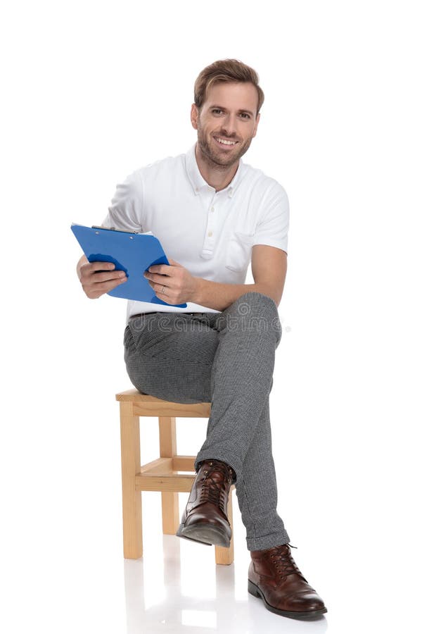 Relaxed casual man sitting and holding a blue clipboard royalty free stock photo Relaxed casual man sitting and holding a blue clipboard royalty free stock photo