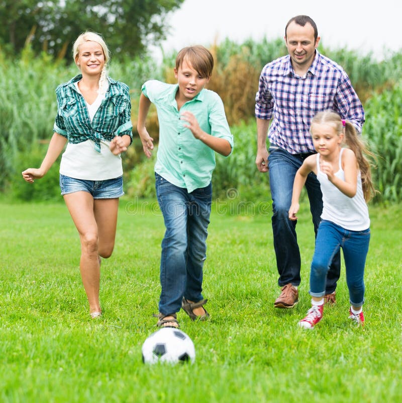 Relaxed family of four people playing football