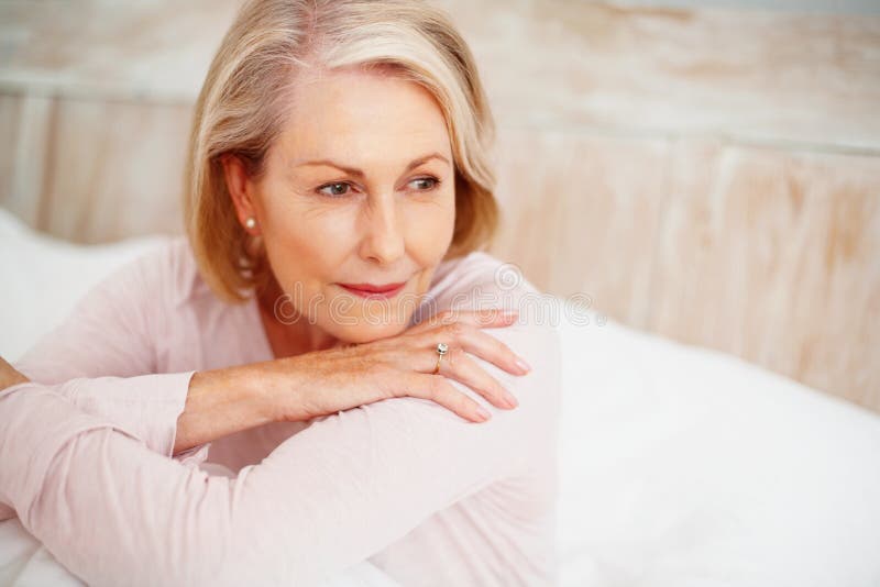 Relaxed Mature Woman In Bed Looking Away Closeup Portrait Of A Relaxed