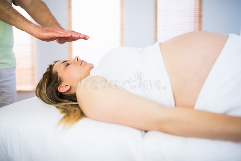 Relaxed pregnant woman getting reiki treatment royalty free stock photos Relaxed pregnant woman getting reiki treatment royalty free stock photos