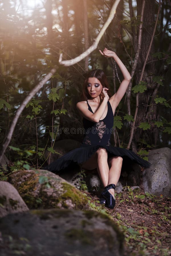 Relaxed Shy And Sexy Young Japanese Ballet Dancer in Black Tutu Posing in Summer Forest and Dreaming With Lifted Hands Over