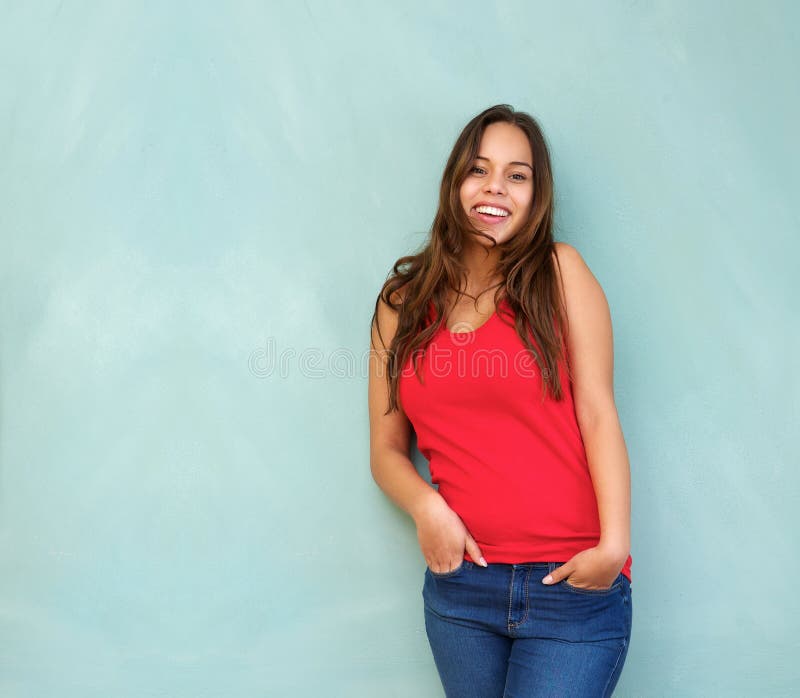 Relaxed young woman in red shirt smiling with hands in pocket