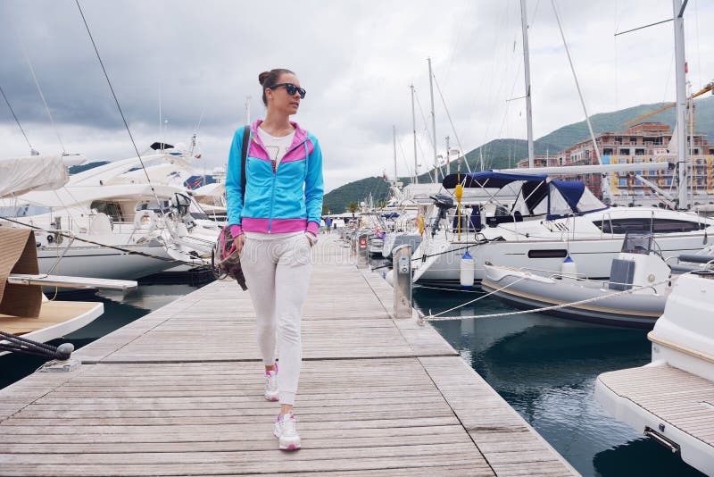 Relaxed young woman walking in marina.