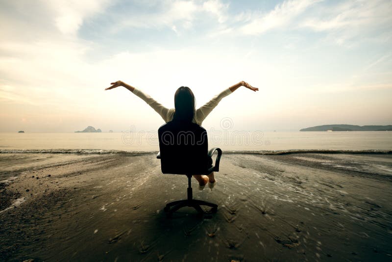 Relaxing business woman sitting on beach