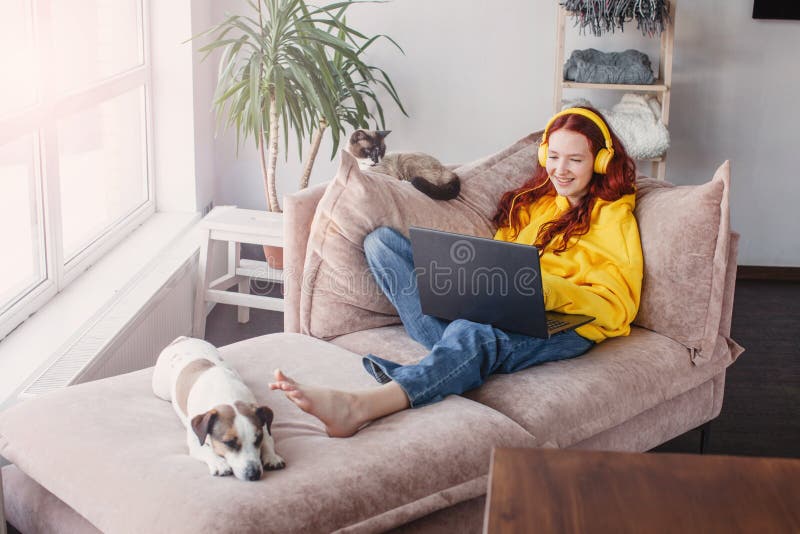 Relaxing young woman using laptop in living room