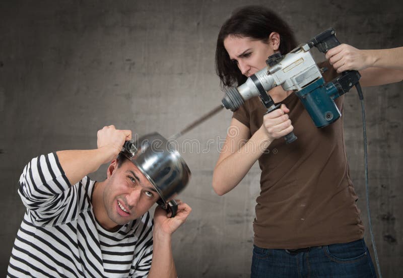 Annoyed women drilling into her boyfriend's head. Annoyed women drilling into her boyfriend's head