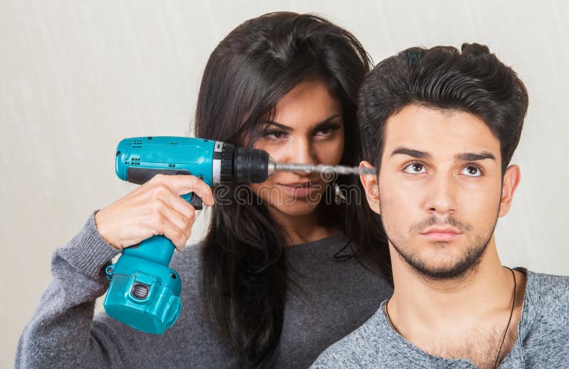 Annoyed women drilling into her boyfriend's head. Annoyed women drilling into her boyfriend's head