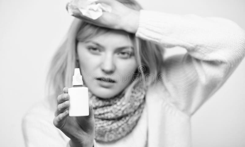 Relieving allergy symptom. Unhealthy girl with runny nose using nasal spray. Sick woman spraying medication into nose royalty free stock photos Relieving allergy symptom. Unhealthy girl with runny nose using nasal spray. Sick woman spraying medication into nose royalty free stock photos