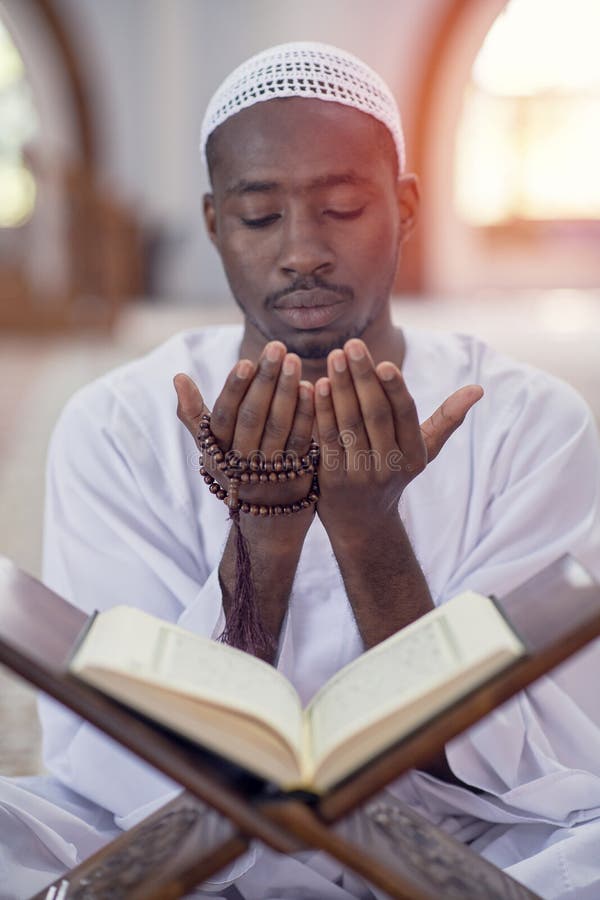 Religious black muslim man praying inside the mosque royalty free stock images
