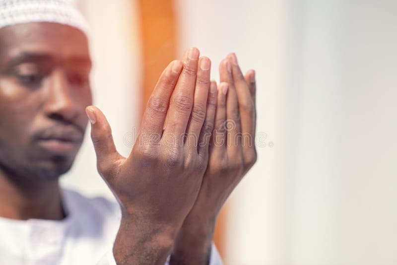 Religious black muslim man praying inside the mosque royalty free stock image