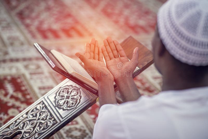 Religious black muslim man praying inside the mosque royalty free stock photography