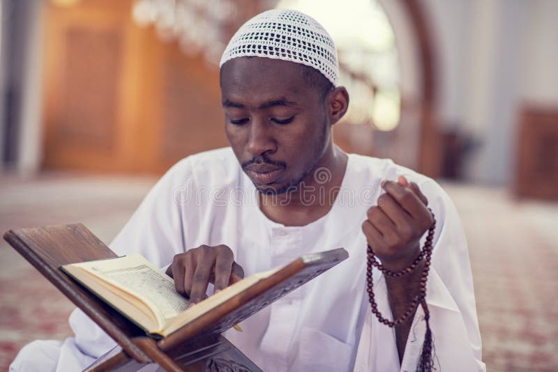 Religious black muslim man praying inside the mosque royalty free stock image