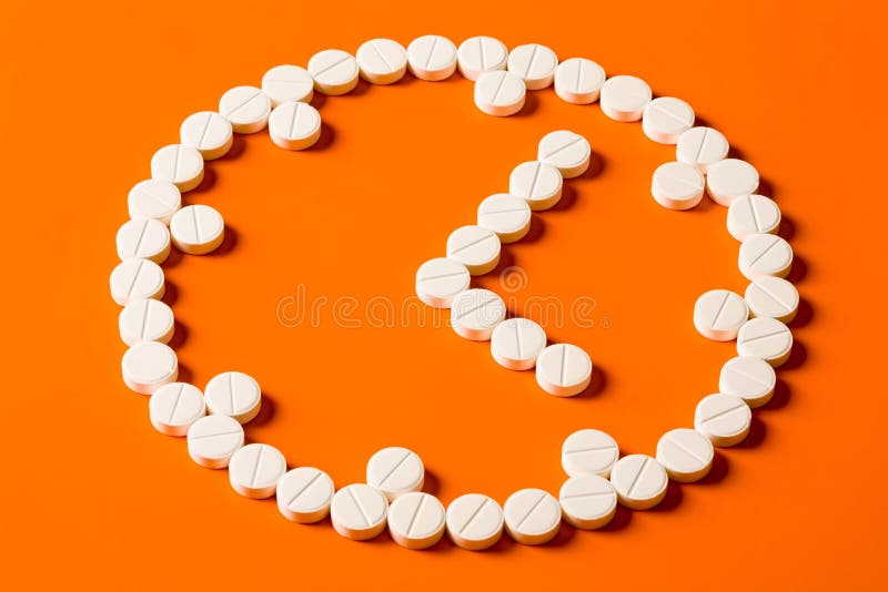 Symbol of watch made up out of white tablets on the orange background. Symbol of watch made up out of white tablets on the orange background