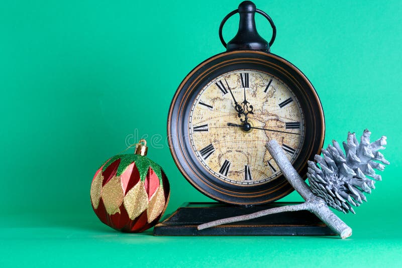 Reloj de Año Nuevo a medianoche, bauble y cono en bran de pino fotos de archivo Reloj de Año Nuevo a medianoche, bauble y cono en bran de pino fotos de archivo