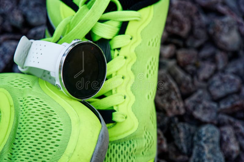 Reloj del deporte para el crossfit y triathlon en las zapatillas deportivas verdes Reloj elegante para el entrenamiento diario de fotografía de archivo Reloj del deporte para el crossfit y triathlon en las zapatillas deportivas verdes Reloj elegante para el entrenamiento diario de fotografía de archivo